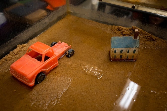 Toy truck stuck in sandbox with water