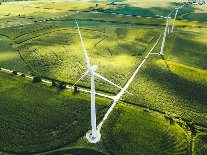 An aerial view of wind turbines in an agricultural field